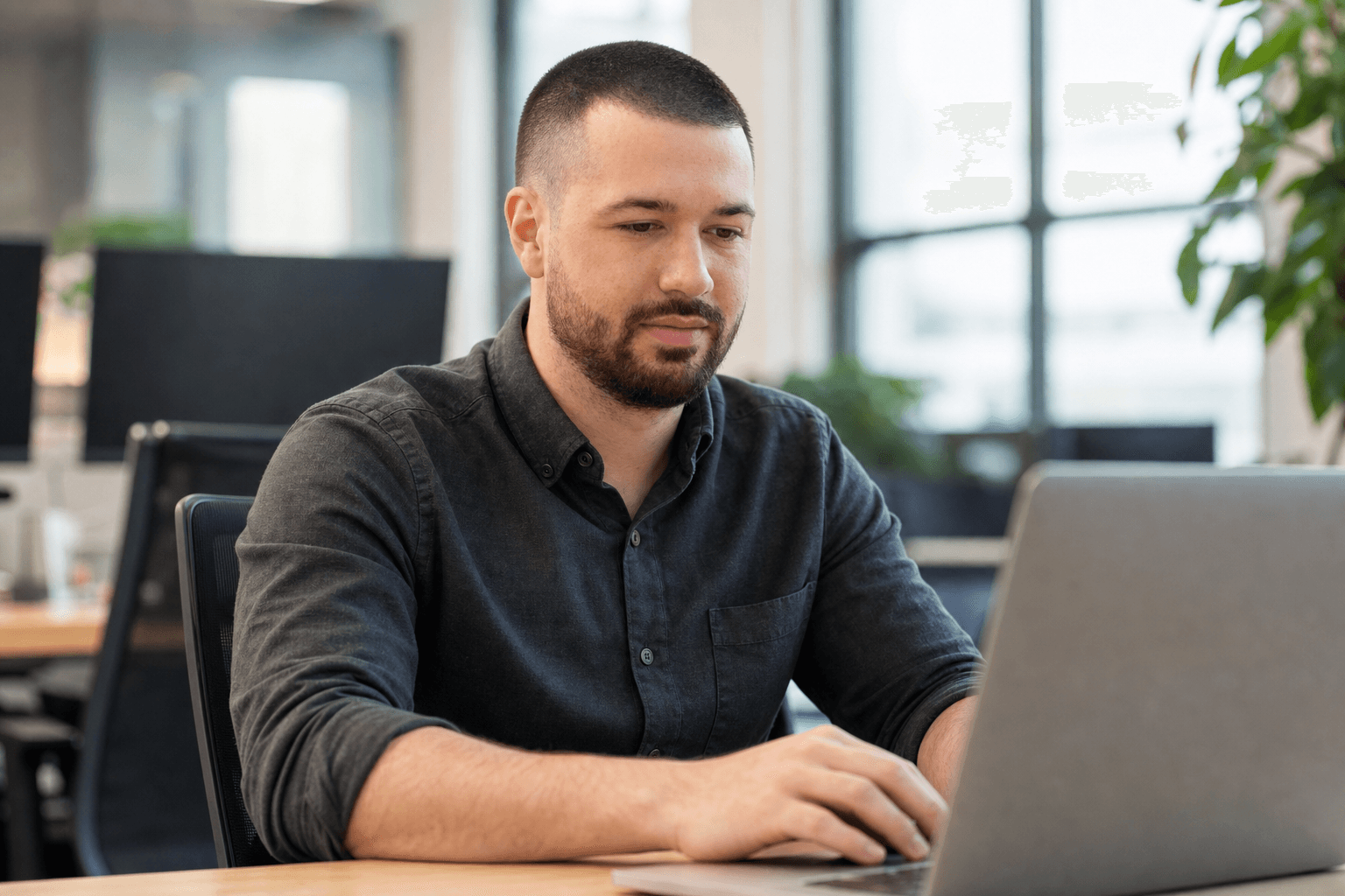 Chandler Drake Talley, Senior AI Engineer — Senior AI Engineer working on a laptop in an office
