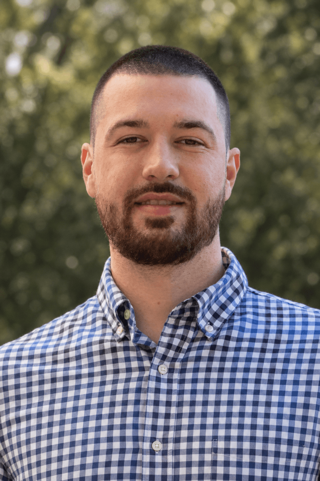 Chandler Talley — outdoor headshot in a gingham shirt