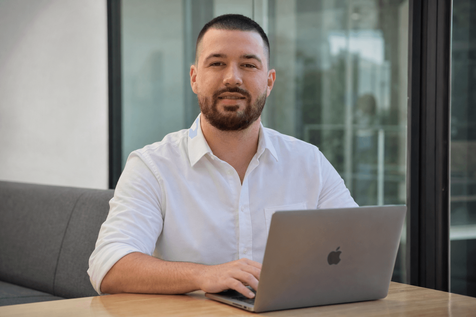 Chandler Talley — typing on a laptop in a huddle room
