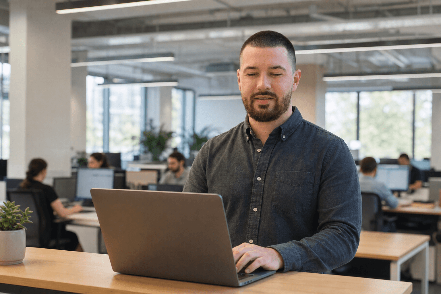 Chandler Talley — working at a standing desk in an open office